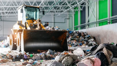 Wheel loader moving mixed waste inside a recycling facility.